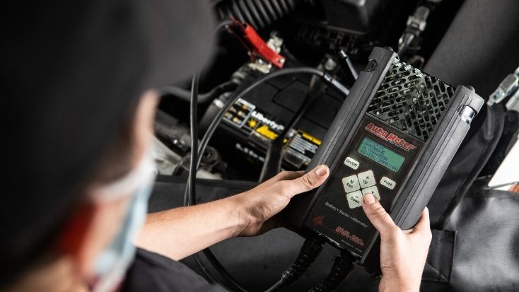 foto de mecánico instalando una batería para carro